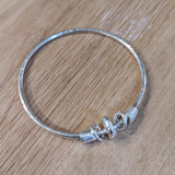 Sterling silver bangle with charms.
